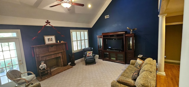 living room with a brick fireplace, vaulted ceiling, ornate columns, and ceiling fan