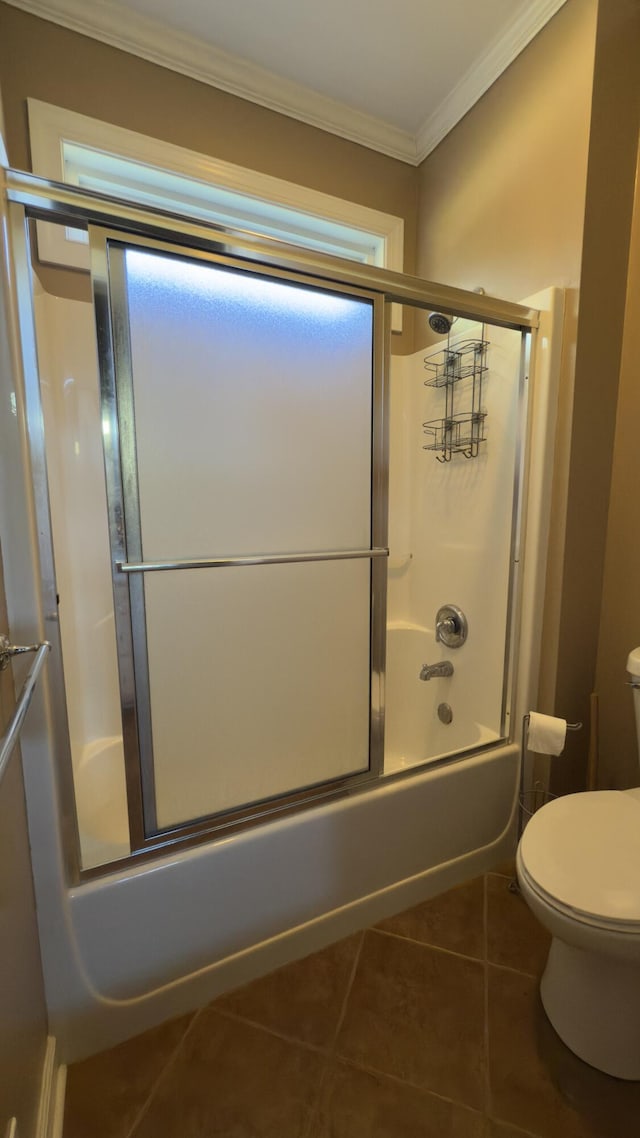 bathroom featuring tile patterned flooring, enclosed tub / shower combo, toilet, and ornamental molding