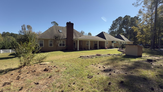 back of property with a yard and a storage shed