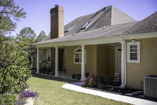 back of house with a yard, ceiling fan, and central air condition unit