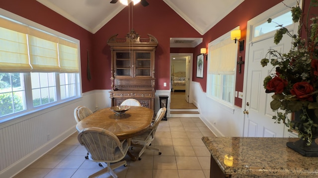 tiled dining room featuring ceiling fan, lofted ceiling, and ornamental molding