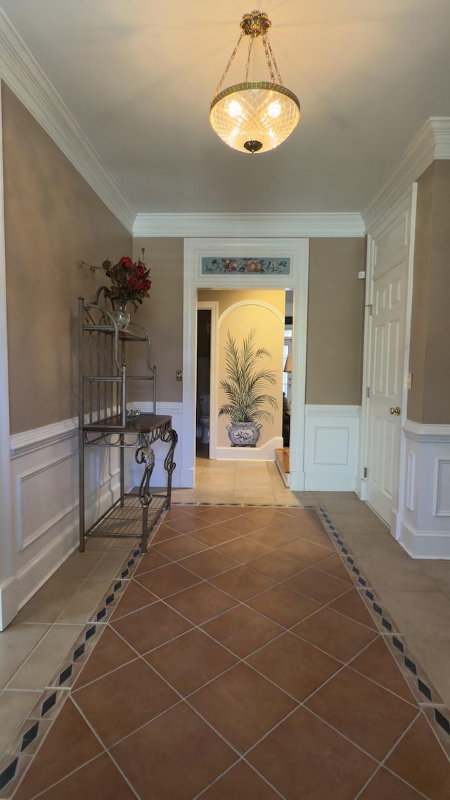 hall with tile patterned flooring and ornamental molding