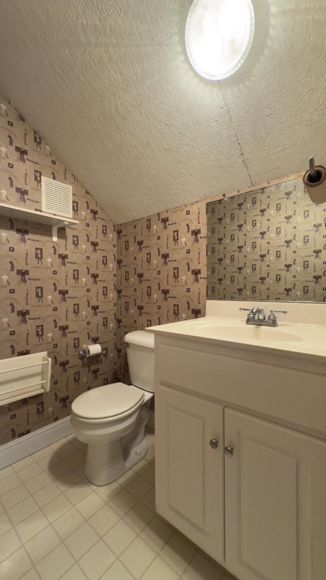 bathroom featuring tile patterned floors, vanity, toilet, and a textured ceiling