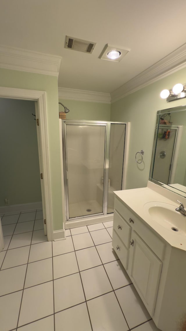 bathroom with tile patterned flooring, vanity, a shower with door, and crown molding