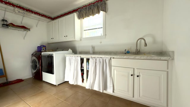 clothes washing area with washing machine and clothes dryer, sink, cabinets, light tile patterned floors, and ornamental molding