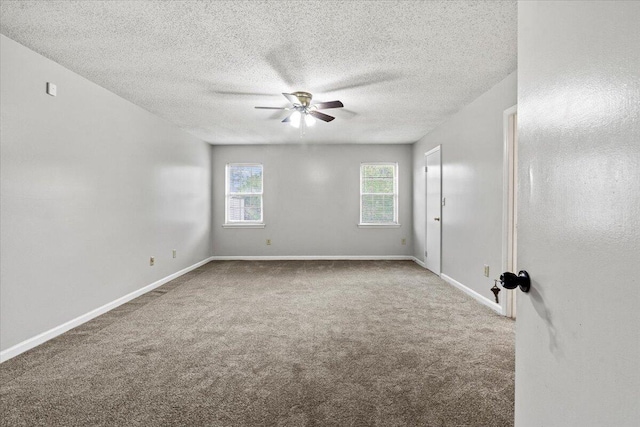 carpeted empty room featuring a ceiling fan, a textured ceiling, and baseboards