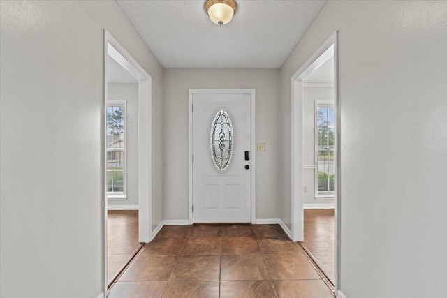 entryway with baseboards and a textured ceiling
