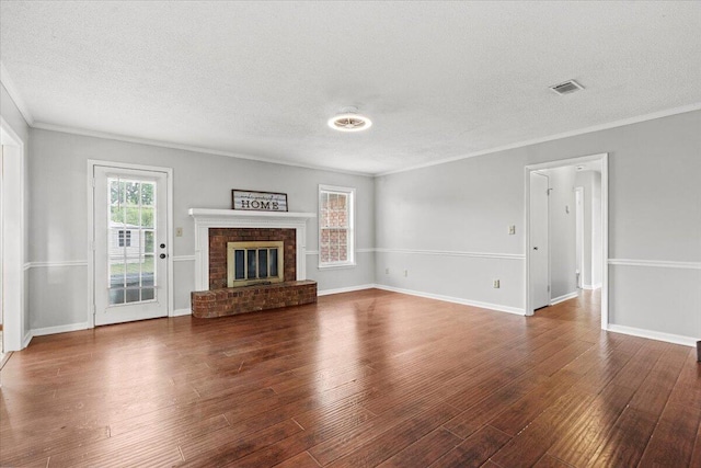 unfurnished living room featuring crown molding, visible vents, baseboards, a textured ceiling, and wood finished floors