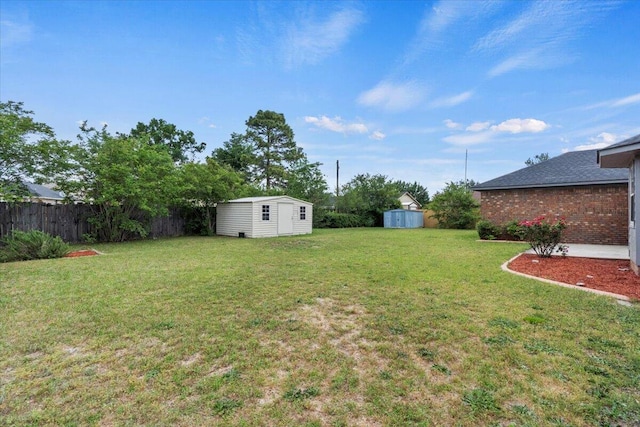 view of yard with fence, an outdoor structure, and a storage shed