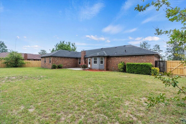rear view of house with brick siding, fence, and a patio area