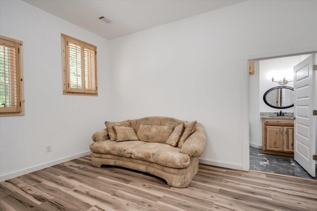 living area featuring plenty of natural light, wood-type flooring, and sink