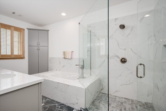 bathroom featuring shower with separate bathtub and vanity