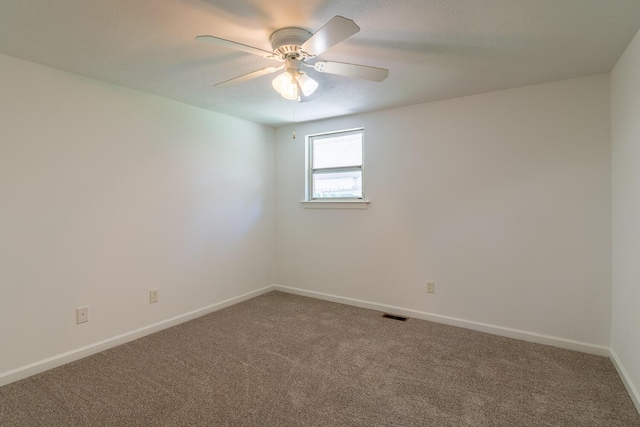 unfurnished room with visible vents, ceiling fan, carpet flooring, and baseboards
