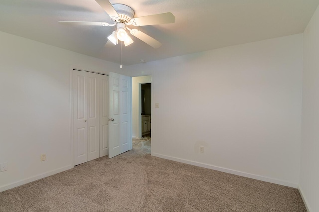 unfurnished bedroom featuring baseboards, ceiling fan, a closet, and light colored carpet