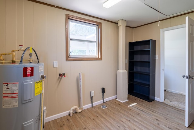 clothes washing area with baseboards, water heater, laundry area, and light wood-style flooring