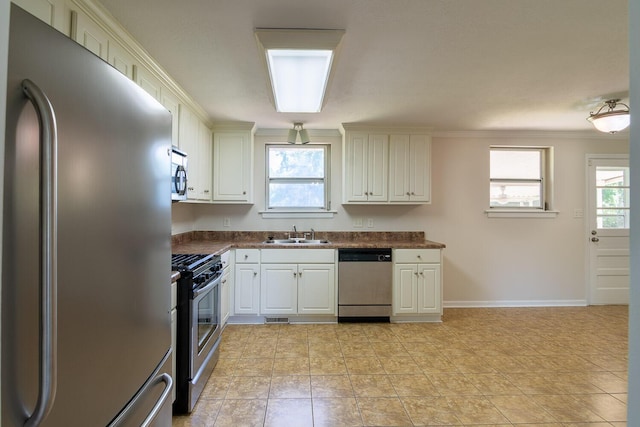kitchen featuring dark countertops, a sink, appliances with stainless steel finishes, and visible vents