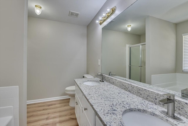 full bathroom featuring a sink, visible vents, toilet, and wood finished floors