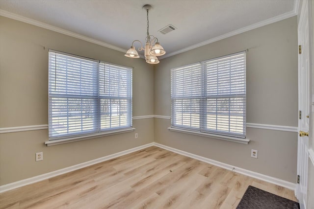 unfurnished dining area with visible vents, plenty of natural light, a notable chandelier, and wood finished floors