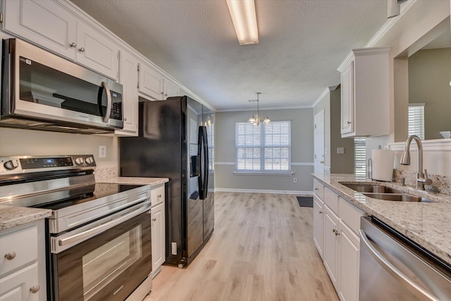 kitchen featuring white cabinetry, stainless steel appliances, crown molding, and a sink