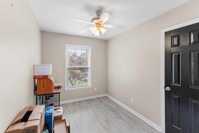 interior space featuring light wood-type flooring, a ceiling fan, and baseboards