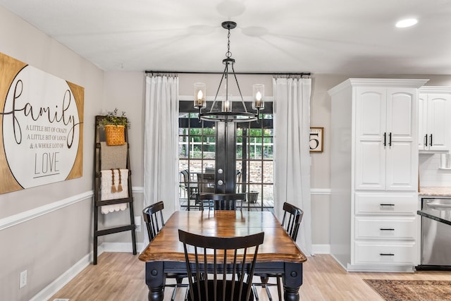 dining area featuring a chandelier, light wood-style floors, and baseboards