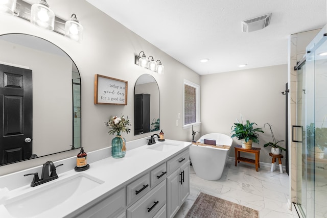 bathroom featuring marble look tiles, a stall shower, a freestanding bath, double vanity, and recessed lighting