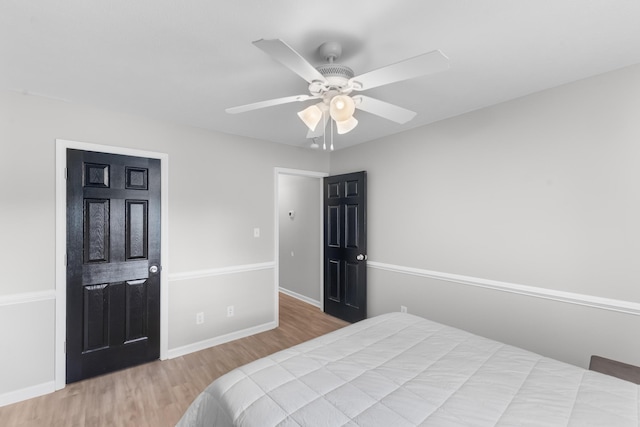 bedroom with wood finished floors, baseboards, and a ceiling fan