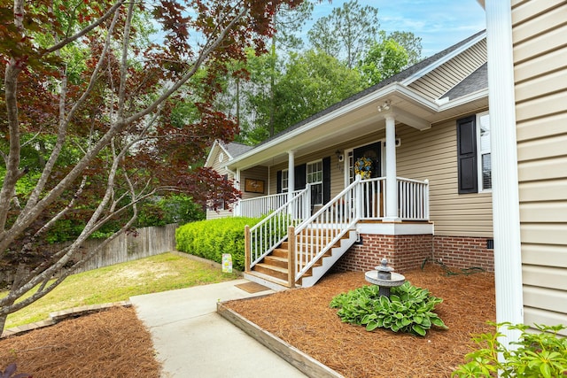 property entrance with roof with shingles and covered porch