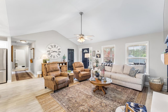 living area featuring light wood-style flooring, vaulted ceiling, ceiling fan, and baseboards