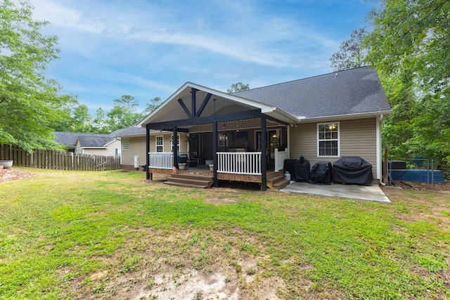 back of house featuring a shingled roof, a patio, and a wooden deck