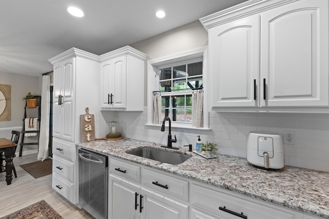 kitchen with dishwasher, a sink, white cabinets, decorative backsplash, and recessed lighting