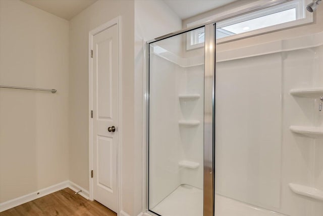 bathroom with a shower stall, a closet, and wood finished floors