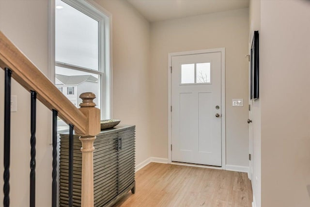 entrance foyer with stairway, light wood-type flooring, and baseboards