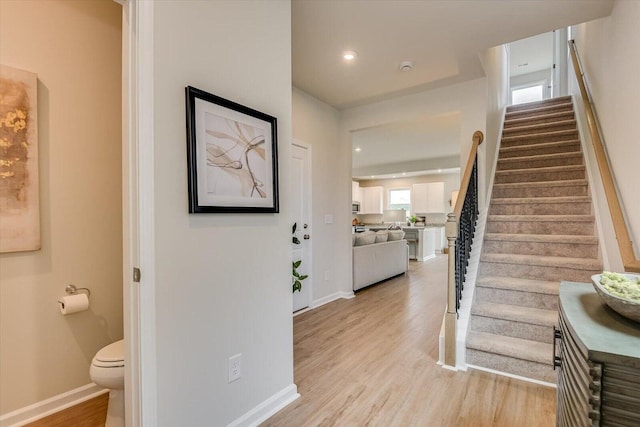 interior space featuring light wood finished floors, stairway, baseboards, and recessed lighting