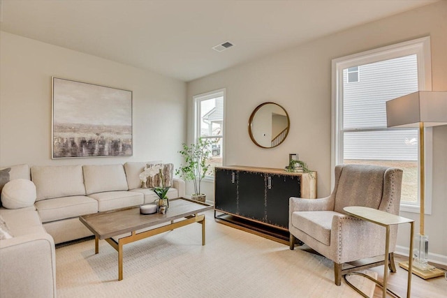 living area featuring wood finished floors, visible vents, and baseboards