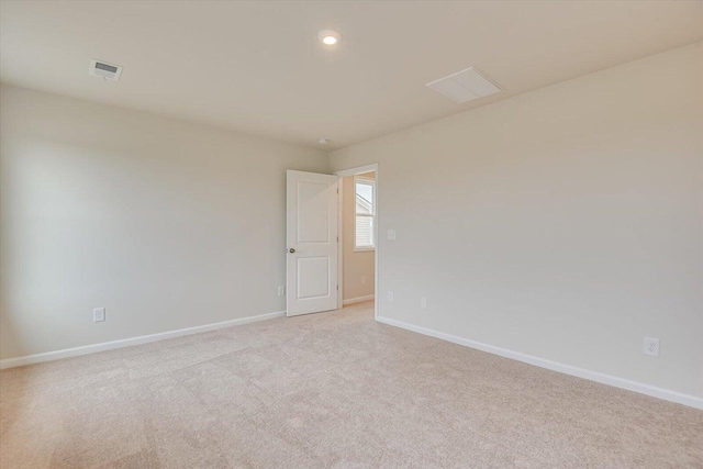 empty room with recessed lighting, visible vents, light carpet, and baseboards