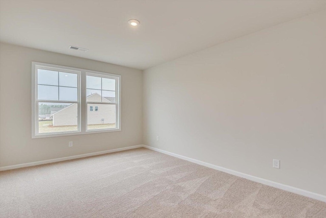 empty room featuring recessed lighting, baseboards, visible vents, and light colored carpet