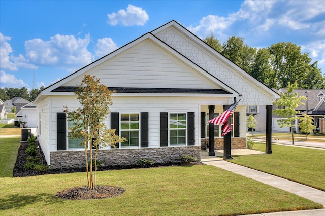 craftsman house featuring cooling unit and a front yard