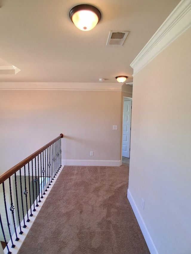 hall with baseboards, carpet, visible vents, and crown molding