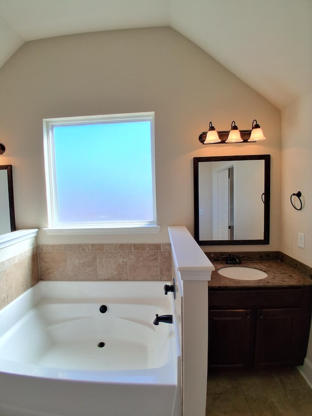 full bath featuring lofted ceiling, tile patterned floors, vanity, and a bath