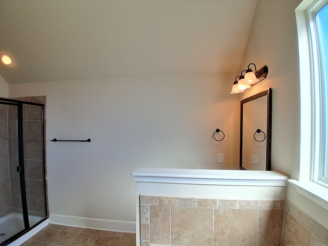 bathroom featuring vaulted ceiling, a stall shower, tile patterned floors, and baseboards