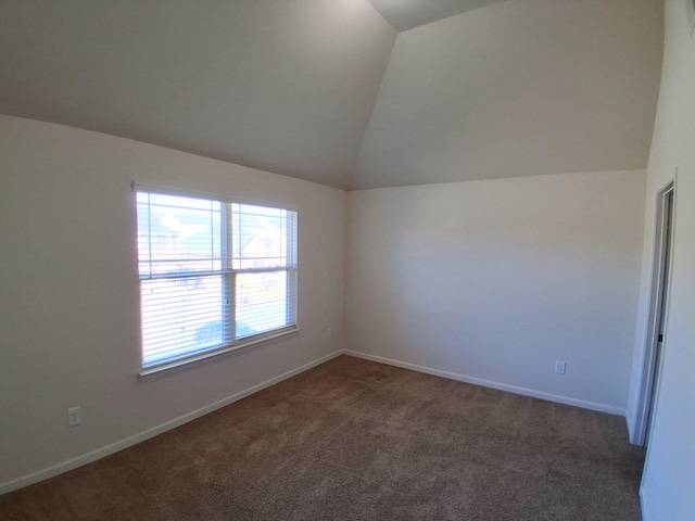 spare room featuring baseboards, vaulted ceiling, and carpet flooring