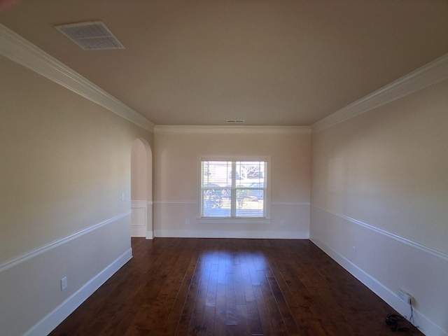 spare room featuring visible vents, arched walkways, dark wood-type flooring, and ornamental molding