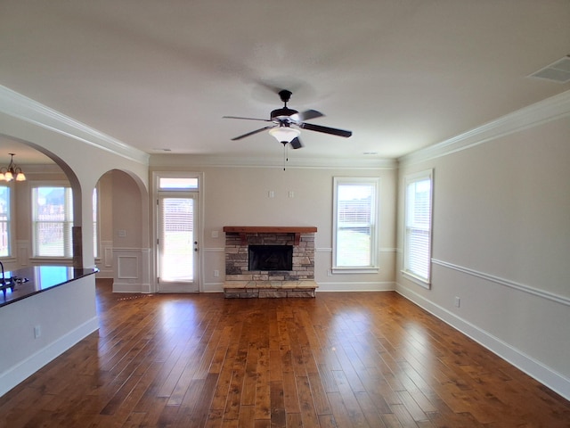 unfurnished living room with dark wood-style floors, ornamental molding, and a fireplace