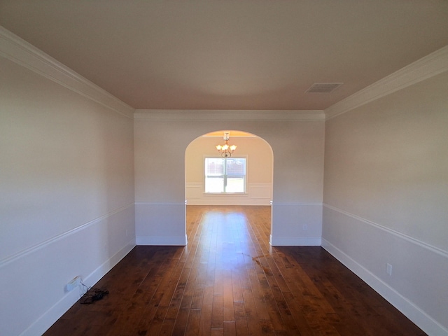 unfurnished room with visible vents, arched walkways, baseboards, dark wood-style floors, and ornamental molding