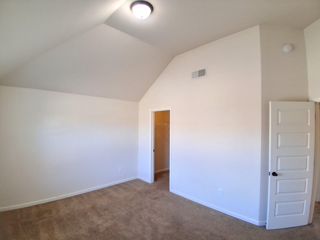 interior space with vaulted ceiling, visible vents, and baseboards