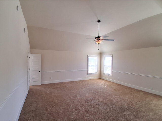 interior space with lofted ceiling, light colored carpet, and baseboards