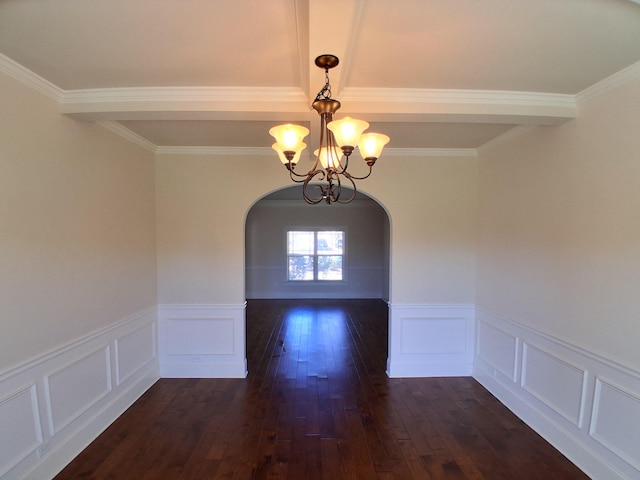 unfurnished dining area with arched walkways, a wainscoted wall, dark wood finished floors, and an inviting chandelier