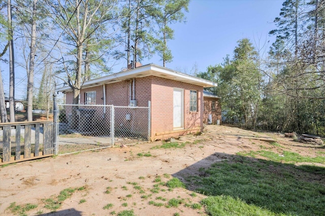 view of side of home featuring brick siding and fence