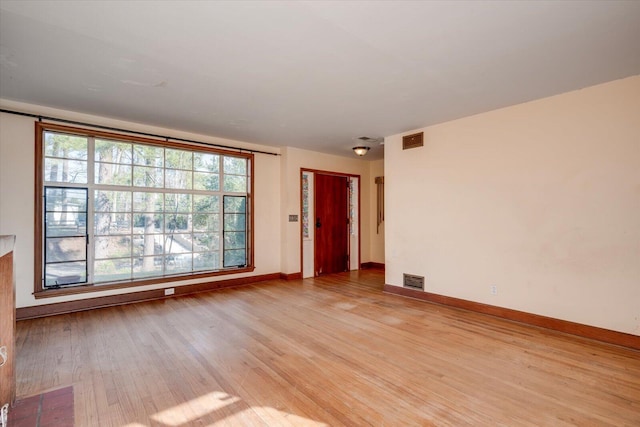 spare room with visible vents, light wood-style flooring, and baseboards